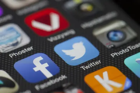 Close-up of smartphone screen with Facebook, Twitter, and other app icons